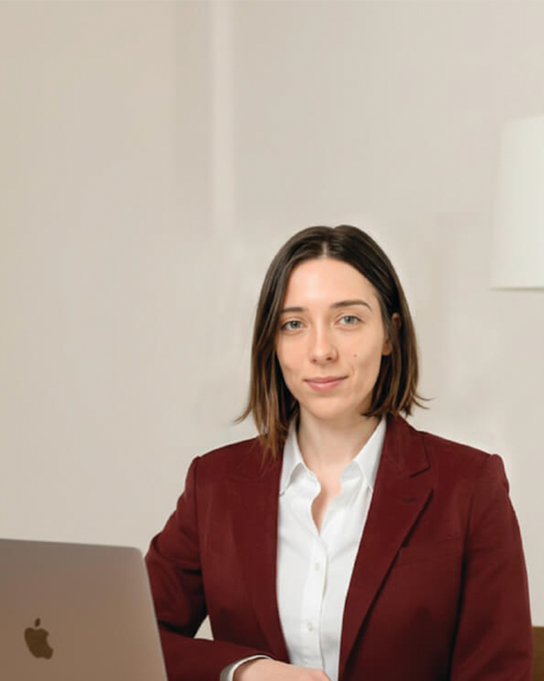 woman sitting at the table in front of an open laptop screen